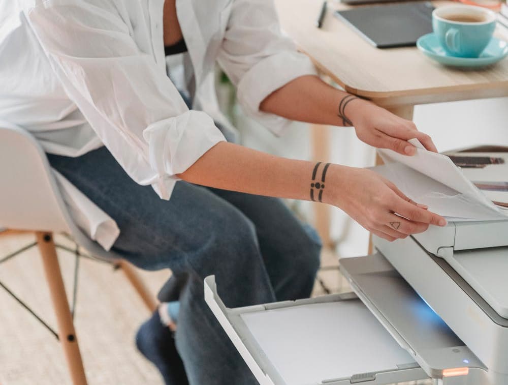 Person printing documents next to their desk